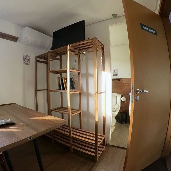 Suíte do Flat do Chef com estante e acesso ao banheiro