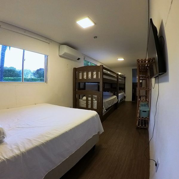 Quarto do Flat da Família com cama de casal, beliche e TV