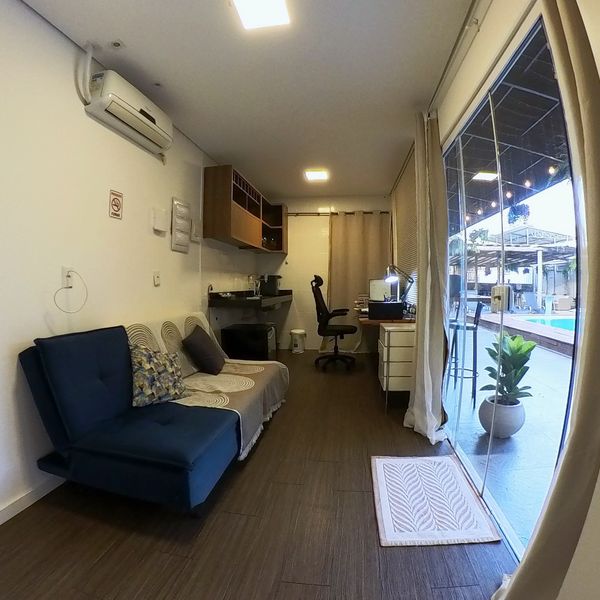 Sala do Flat dos Solteiros com sofá e cozinha compacta