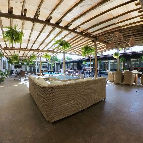 Lounge com sofás de vime no pátio coberto