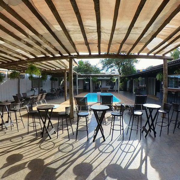 Mesas altas e banquetas junto à piscina