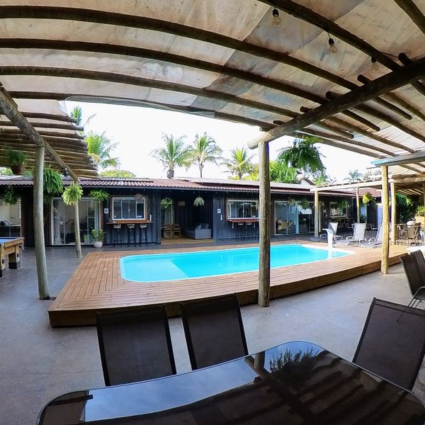 Piscina com deck de madeira e espreguiçadeiras