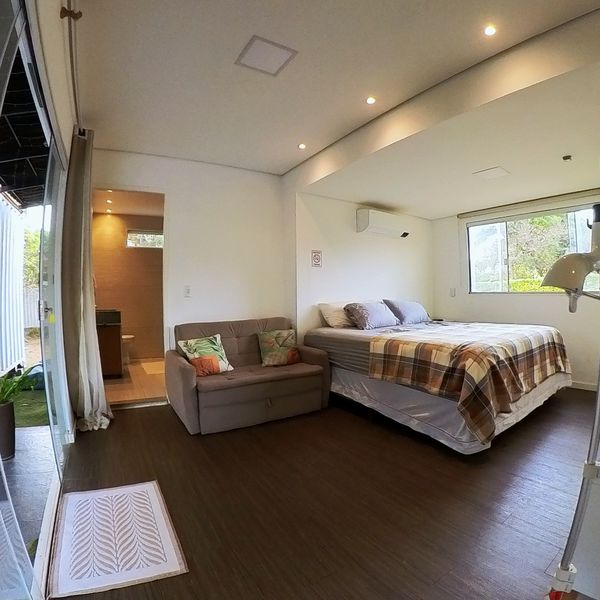 Suíte do Amor vista da entrada, com sofá e cama de casal